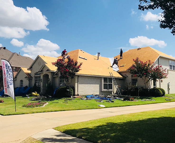 Workers installing new roof on house.